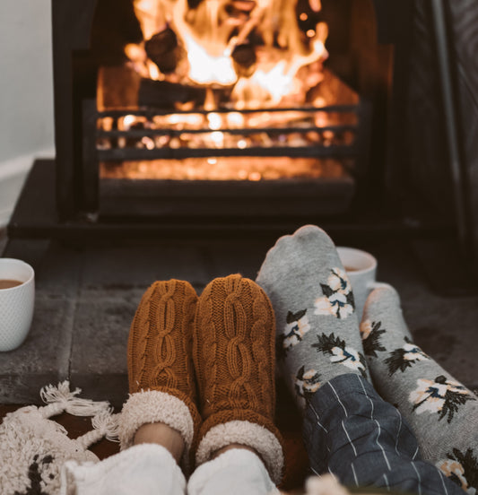 Two people sitting together in front of a log burner.